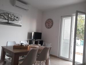 a dining room with a table and chairs and a clock at Apartment Tea in Primošten