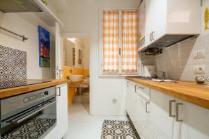 La cuisine est équipée de placards blancs et d'un four avec plaques de cuisson. dans l'établissement Casa Sole, à Florence