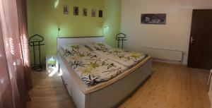 Bett in einem Zimmer mit grüner Wand in der Unterkunft Ferienwohnung Familie Slepitzka in Niedenstein
