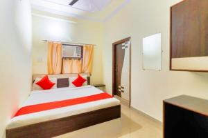 a bedroom with a bed with red pillows at Hotel Station View Mughalsarai by ShriGo Hotels in Mughal Sarāi