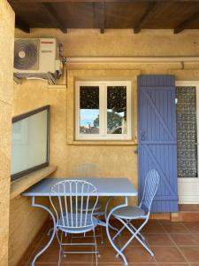 une table et des chaises dans une pièce avec un écran dans l'établissement Appartements " Le Clos De La Cerisaie", à Castillon-du-Gard