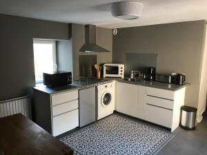 a kitchen with a washing machine and a microwave at Au pied du Chateau de Chaumont sur Loire in Chaumont-sur-Loire