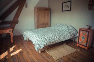 a bedroom with a bed and a wooden floor at gite-il était une fois in Bailleul