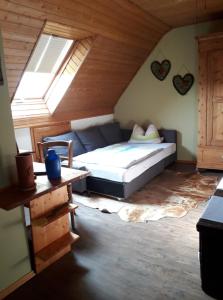 Stierstall-Suite Pension Wahlenau في Wahlenau: غرفة نوم بسرير ونافذة في العلية