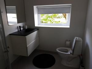 a bathroom with a toilet and a sink and a window at Small Paradise in Sørvágur