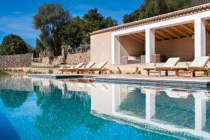a pool with lounge chairs next to a house at Son Grua Agroturismo - Adults only in Pollença