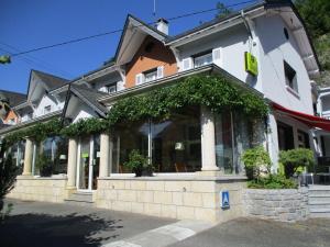 un grande edificio con finestra e piante di Logis Hôtel L'Ayguelade a Bielle