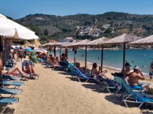 a group of people sitting in lawn chairs on a beach at Dodis Village in Platanias