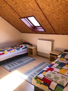 a attic bedroom with two beds and a skylight at Vadvirág vendégház in Lenti