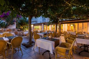 un restaurante con mesas, sillas y un árbol en Houm Plaza Son Rigo, en Playa de Palma