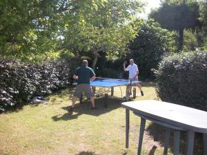two men playing ping pong on a ping pong table at Almigeda in Les Mathes