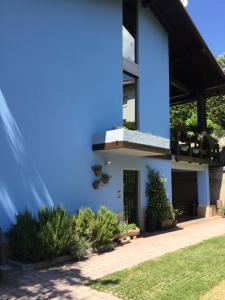 a blue house with plants in a yard at BnB Trento in Trento