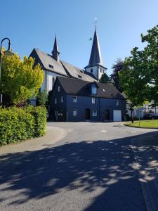 a large blue building with a church in the background at Pilgrims "Elfriede"- freundliche Unterkunft in Remblinghausen