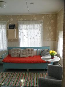 1 dormitorio con cama roja y mesa en Kirkkokadun Amanda ja Olga, en Uusikaupunki