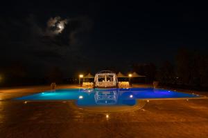 een zwembad 's nachts met de maan op de achtergrond bij Il Borgo Ariccia Resort in Ariccia