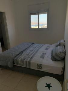 een bed in een slaapkamer met een raam bij Appartement à Eilat vue mer in Eilat