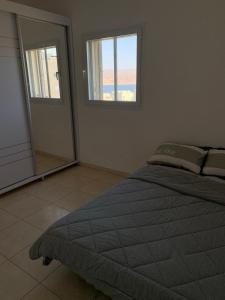 een slaapkamer met een bed en een grote spiegel bij Appartement à Eilat vue mer in Eilat