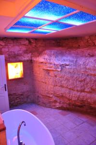een badkamer met een bad en een plafond met blauwe verlichting bij Mas de Foncaudette in Lourmarin