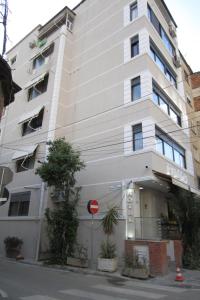 un edificio blanco con un letrero de la calle delante de él en Freddy's Hotel en Tirana