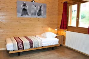 een slaapkamer met een bed in een houten wand bij Chalet Skadi in La Bresse