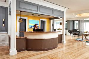 a woman standing at a bar in a lobby at The Bristol Hotel San Diego in San Diego