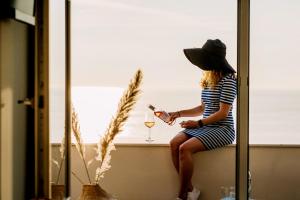 a woman sitting on a window sill with a glass of wine at Boulevard 5 in Zandvoort