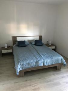 a bedroom with a bed with blue pillows on it at Apartments Lena in Baška