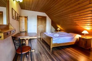 sypialnia z łóżkiem i drewnianym sufitem w obiekcie Pension Dymník w mieście Rumburk