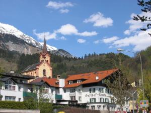 ein großes weißes Gebäude mit einer Kirche in den Bergen in der Unterkunft Gasthof Koreth in Innsbruck