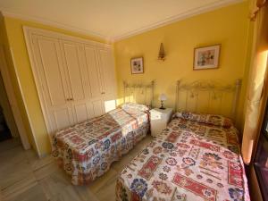2 camas en una habitación con paredes amarillas en Apartamento Las Mimosas Beach, en La Cala de Mijas