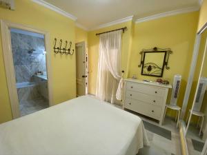 a bedroom with a white bed and a bathroom at Apartamento Las Mimosas Beach in La Cala de Mijas