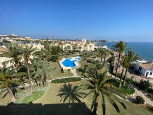 an aerial view of a resort with a pool and palm trees at Apartamento Las Mimosas Beach in La Cala de Mijas