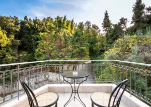 een balkon met een tafel, stoelen en bomen bij Marina's Elegance in Kriopigi