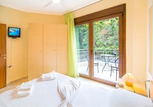 a bedroom with a bed and a balcony with a table at Marina's Elegance in Kriopigi