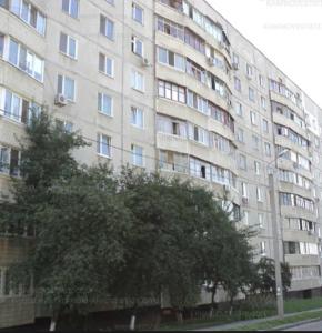 un grande edificio con un albero di fronte di Замечательная квартира с современным ремонтом рядом с метpо Холодная гора a Charkiv