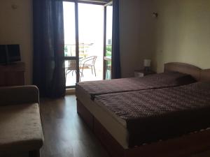 a bedroom with a bed and a sliding glass door at Къща за гости Емона,Обзор in Obzor +37 photos