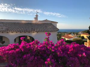 uma casa com flores roxas em frente em Magic Dream Seaview Villa Denia with 2 Pools, BBQ, Airco, Wifi em Denia