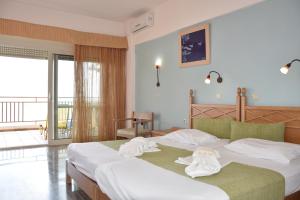 a hotel room with two beds with towels on them at Thalassa House Apartments in Plakias