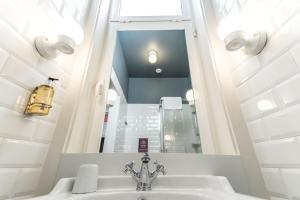 La salle de bains est pourvue d'un lavabo et d'un miroir. dans l'établissement Home Lisbon Hostel, à Lisbonne