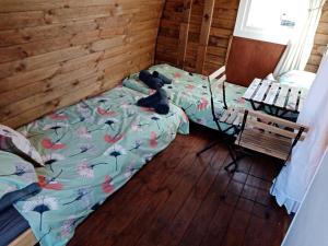 a bedroom with a bed with a cat laying on it at Wee Hoose Glamping Pod 1 in Skail