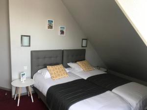 two twin beds in a room with a attic at Le Canada in Hermanville-sur-Mer