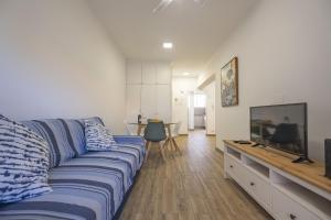 a living room with a blue couch and a flat screen tv at Apartment - The Historical Center of Funchal in Alojamento Local in Funchal