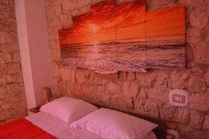 a bedroom with a stone wall with a picture of the ocean at Appartamento Gennirco in Baunei