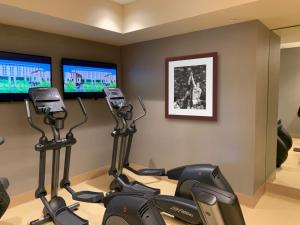 a gym with two monitors and two exercise bikes at Luskin Hotel in Los Angeles