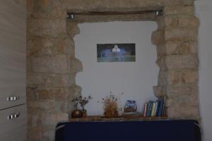 Habitación con una pared de piedra con una foto en la pared. en Appartamento Gennirco, en Baunei