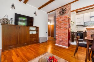 a kitchen and living room with a brick wall at Apartamenty4you - SleepWell Apartment in Sopot