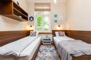 1 Schlafzimmer mit 2 Betten und einem Fenster in der Unterkunft Apartamenty4you - SleepWell Apartment in Sopot