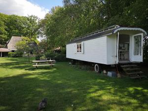 een kleine witte trailer in een tuin met een picknicktafel bij Bed & Breakfast Markelo in Markelo