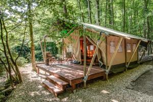 a tent with a deck in the woods at Africa House in Zlín