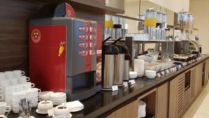 um balcão com chávenas e uma máquina de café em Tulip Inn Sete Lagoas em Sete Lagoas